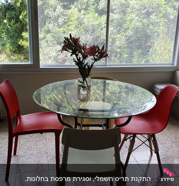 שולחן זכוכית עגול עם כיסאות אדומים